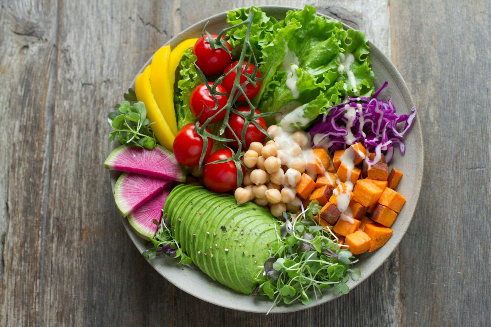 Skål med färgrik sallad av grönsaker, bönor och avokado
